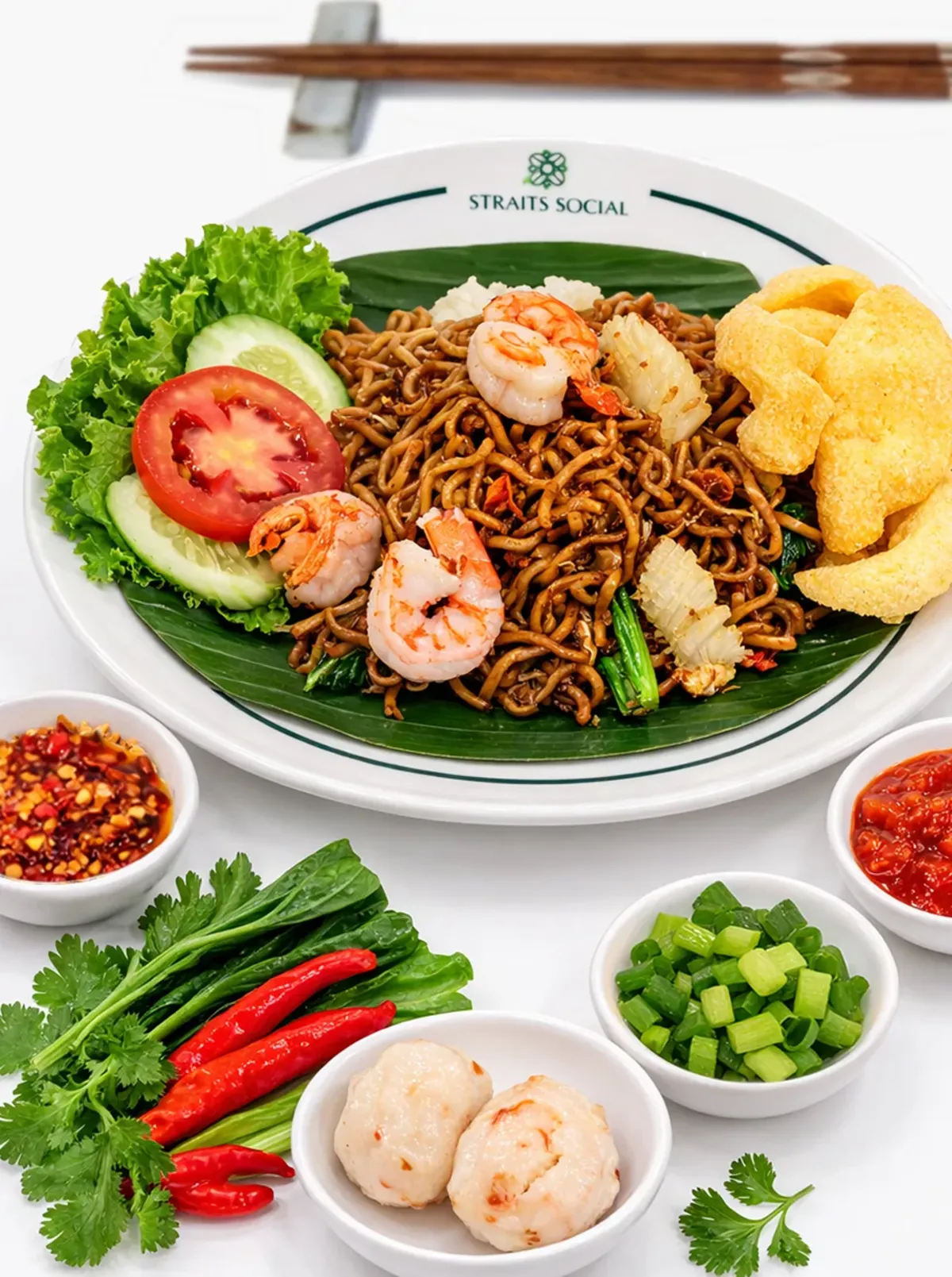 A plate of prawn fried noodles with its garnishes